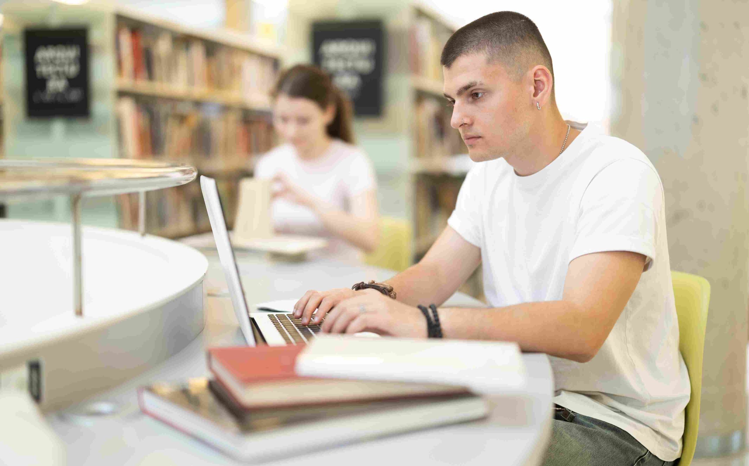 Student koristi laptop u biblioteci dok istražuje informacije