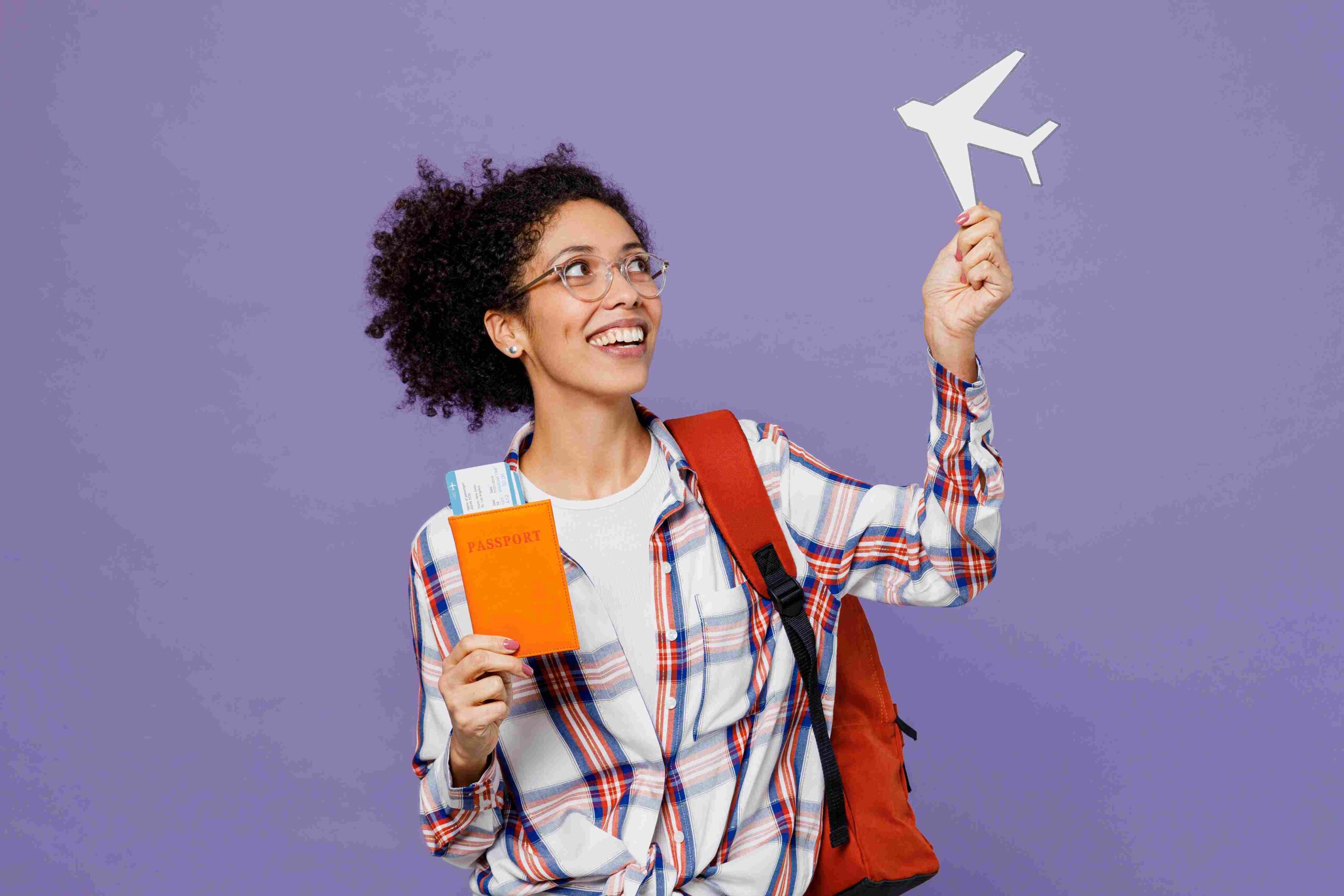 Studentkinja drži pasoš i avionsku kartu dok zamišlja putovanje